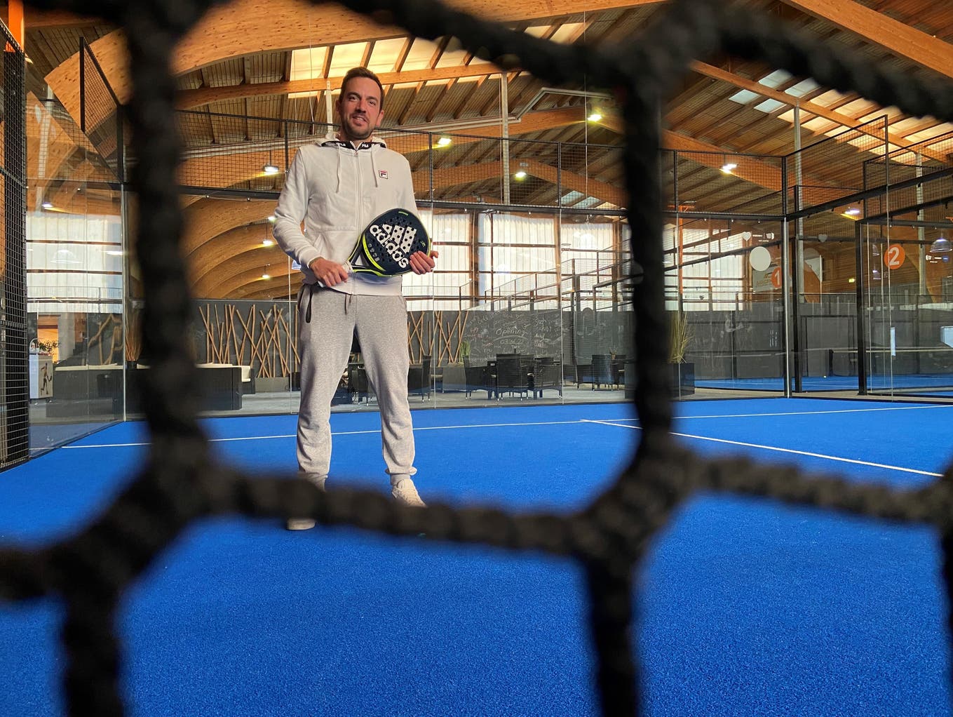 Padelspieler Muhamed Fetov im Barreggcenter in Baden in der Halle mit einem Schläger in der Hand.