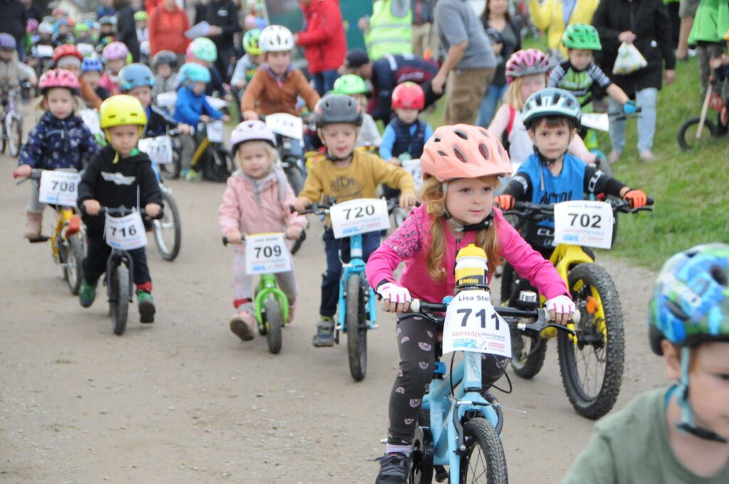 Mehrere Kinder messen sich bei einem Velorennen.