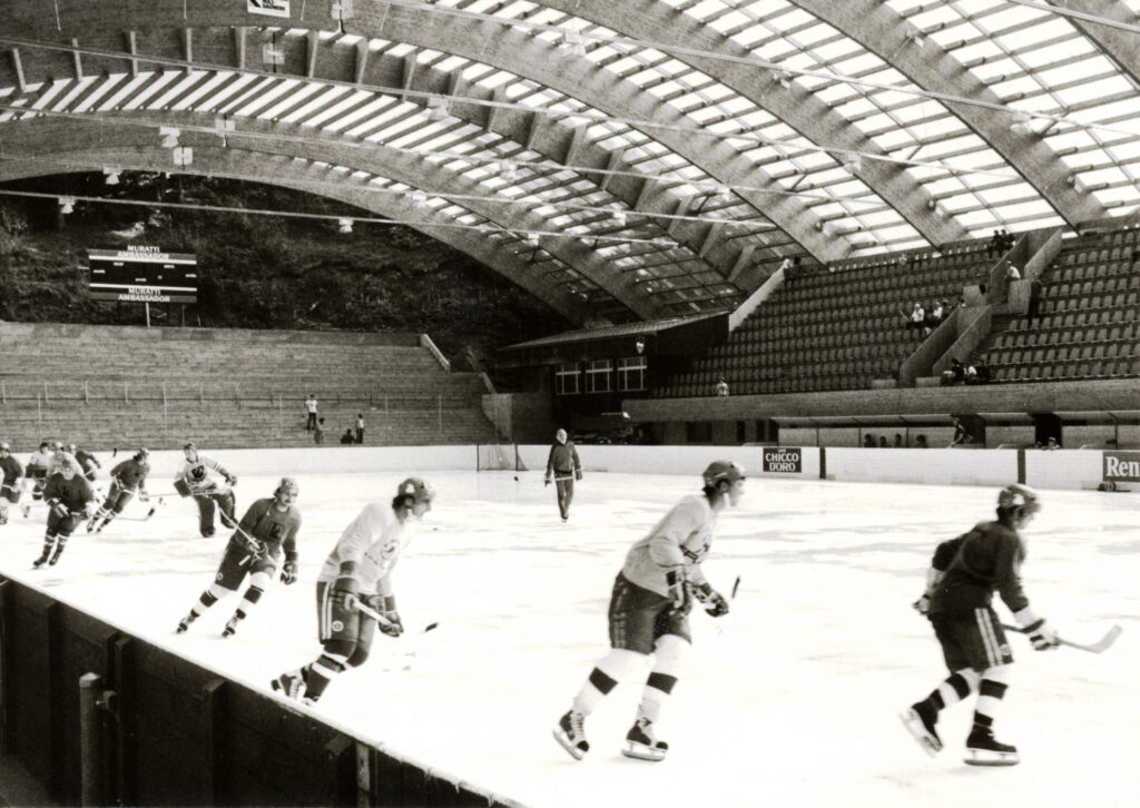 Im Eishockeystadion Valascia fahren einige Spieler rum. Das Bild ist schwarz weiss und schon einige Jahre alt.