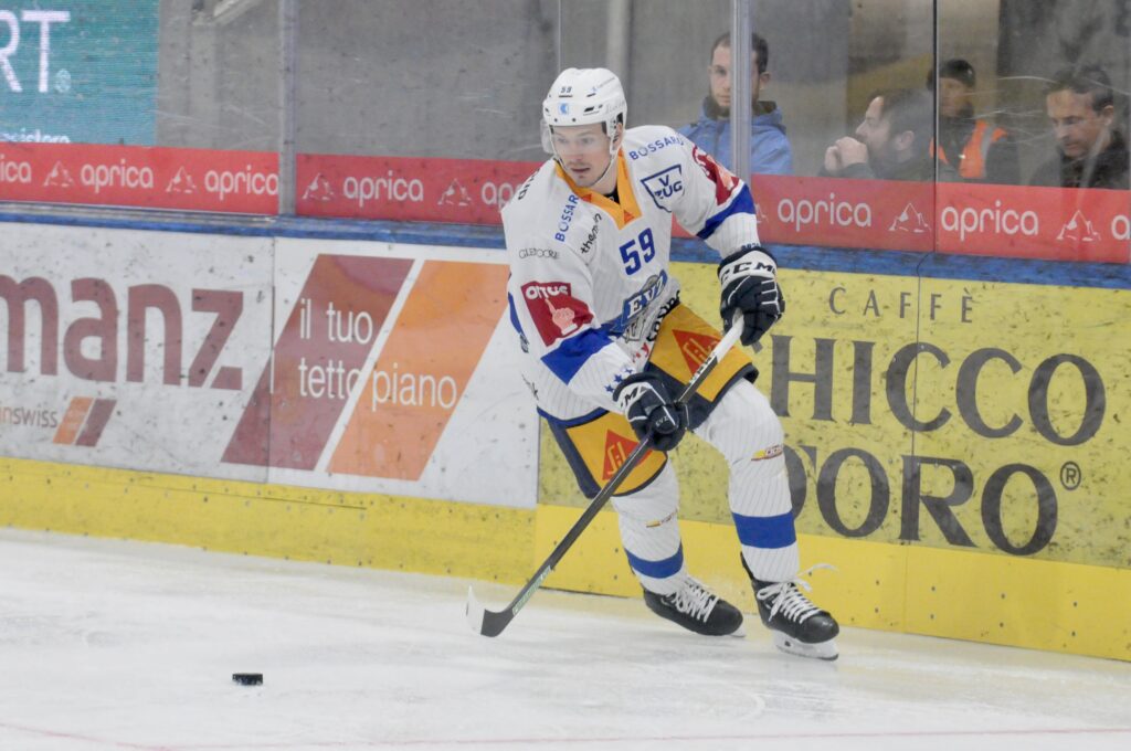Der Eishockeyspieler Dario Simion sprintet dem Puck hinterher.