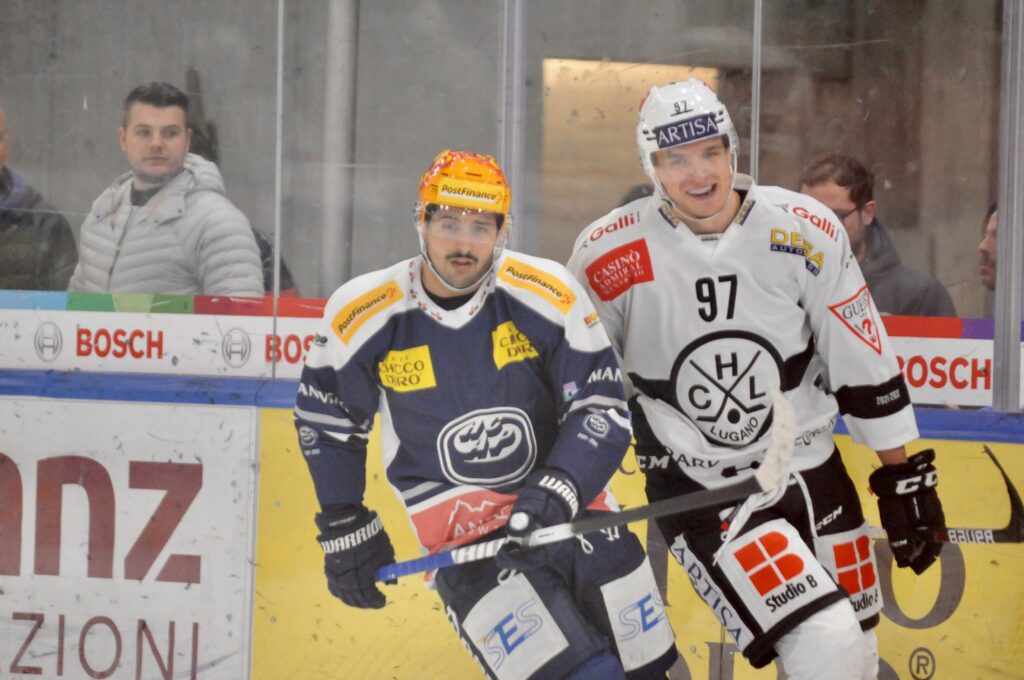 Zwei Eishockeyspieler lachen während dem Spiel.